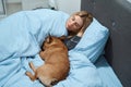 Peaceful young woman and her pet resting in bedroom Royalty Free Stock Photo