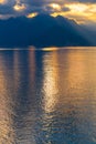 Tranquil lake illuminated by the setting sun, casting a mesmerizing reflection