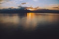 Tranquil lake illuminated by the setting sun, casting a mesmerizing reflection