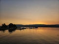 Tranquil lake scene with a golden sunset sky illuminating the horizon Royalty Free Stock Photo