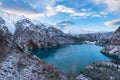 Tranquil landscape of an alpine lake, surrounded by majestic snow-covered mountains