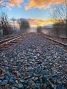 Tranquil landscape of train tracks winding through a lush forest, featuring autumn foliage Royalty Free Stock Photo