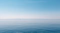 Tranquil minimalist landscape with a smooth blue sea surface with calm waters with a horizon and clear skies.