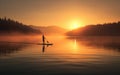 Tranquil misty lake with a silhouetted man on a standup paddle board against the sunset. Beautiful landscape and paddleboard Royalty Free Stock Photo