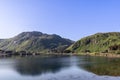 A tranquil morning view of a still fjord in Northern Norway, with lush green hills and a small cluster of red houses at the water Royalty Free Stock Photo