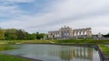 a long pond with lots of water surrounding it and a large building in the background