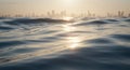 Tranquil ocean waves at sunset with city skyline in background Royalty Free Stock Photo