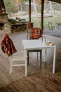 Tranquil outdoor patio with a wooden floor, a traditional picnic table, and two white chairs Royalty Free Stock Photo
