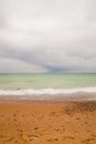 Tranquil Overcast Beach with Gradient Sea and Pebble-Strewn Shoreline