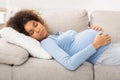 Tranquil pregnant woman sleeping on back and embracing belly