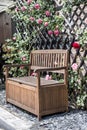 Tranquil relax romantic garden bench surrounded red and pink roses blossom bushes Royalty Free Stock Photo