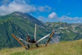 Tranquil Retreat: Man in Black Apparel Resting in Hammock Amidst Lush Mountain and Azure Sky Scenery