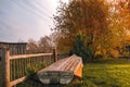 Tranquil rural landscape with a wooden fence, an old upturned boat, and autumn trees Royalty Free Stock Photo