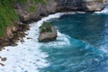 Tranquil scene of the blue ocean lapping against the green cliffs of the shoreline