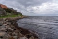 Tranquil scene of a gentle stream of water cascading over rocks and a protective sea wall in Sweden Royalty Free Stock Photo