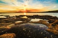 Tranquil scene of a picturesque shoreline bathed in a golden glow from the setting sun