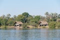 Tranquil scene of several traditional stilted huts in Zambezi River near Victoria Falls, Zimbabwe