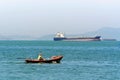 Tranquil Scenery of Fisherman on Small Boat with Large Nautical Vessel in Distant Royalty Free Stock Photo