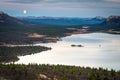 Tranquil scenery with full moon rising over the mountain top during blue hour in the mountains. Royalty Free Stock Photo