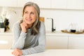 Tranquil senior woman with gray hair spends leisure at home