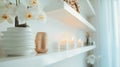 Tranquil shelf setup featuring orchids, textured vase, and lit candles for a spa ambiance. Royalty Free Stock Photo