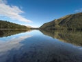 The tranquil South Mavora Lake surrounded by lush thick native forest in rural Southland New Zealand