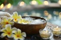 Tranquil spa setting with a wooden bowl of water, flowers, and candles, evoking relaxation Royalty Free Stock Photo