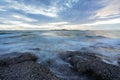 Tranquil stony bay after sunset. Slow shutter speed for smooth water level and dreamy effect. Royalty Free Stock Photo