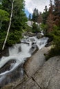 Tranquil stream flows through a picturesque landscape with large rocks and trees