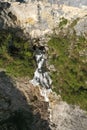 Tranquil stream of fresh, crystal-clear water flowing over a bed of jagged rocks