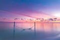 Tranquil summer vacation or holiday landscape. Tropical sunset beach over calm sea water and swing or hammock Royalty Free Stock Photo