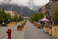 Tranquil urban street scene featuring trees, buildings, and benches at the curbline