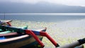 The tranquil view of the lake with calm water and peaceful morning atmosphere. Closeup part of colorful wooden fishing boats Royalty Free Stock Photo