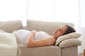 Tranquil woman embracing belly while sleeping on back Royalty Free Stock Photo