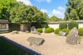 Japanese rock garden with raked pebbles, trimmed bushes, and enclosing wall