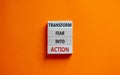 Transform fear into action symbol. Businessman holds wooden blocks with words `Transform fear into action`. Beautiful orange