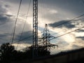 Transformer line tower against a cloudy sunset. In foreground there isa tower with ham radio antenna Royalty Free Stock Photo