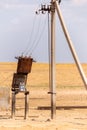 Transformer station near a pillar in steppe. Rural power lines. Electric generators connected to line Royalty Free Stock Photo