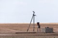 Transformer station near a pillar in steppe. Rural power lines. Electric generators connected to line Royalty Free Stock Photo