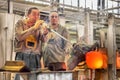 Transforming a hot mass of glass drawn from a hot oven into a work of art. The glass making process up close. Glass master blowing