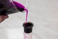 The transfusion of the substance purple, potassium permanganate, from a chemical glass into a bottle. Laboratory