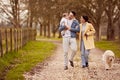 Transgender Family With Baby And Pet Dog  Enjoying Walk In Autumn Or Winter Countryside Royalty Free Stock Photo