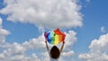 Transgender holding LGBT flag on sky background