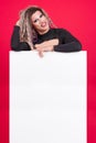 Transgender person with make up leaning on a blank panel