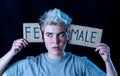 Transgender teenager breaking the word FEMALE into MALE. Gender identity and human rights concept