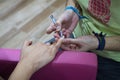 Transgender woman in the beauty salon and she is getting a manicure by the professional nail stylist. Beauty and health center.