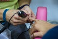 Transgender woman in the beauty salon and she is getting a manicure by the professional nail stylist. Beauty and health center.