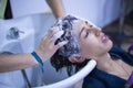 Transgender woman shampooing her hair for a keratin treatment at a hair salon. Transgender concept, hairdresser, beauty