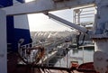 Transhipment terminal for unloading bulk cargo of chemical sulfur from ships using a coastal crane. Port of Zorf-Lasfar, Morocco.