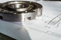 The transition flange after processing lies on the technical drawing. Detail ready to work with a drawing together in mechanical Royalty Free Stock Photo